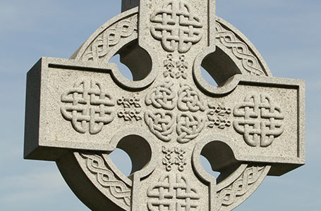 Stone Celtic cross with a blue sky background