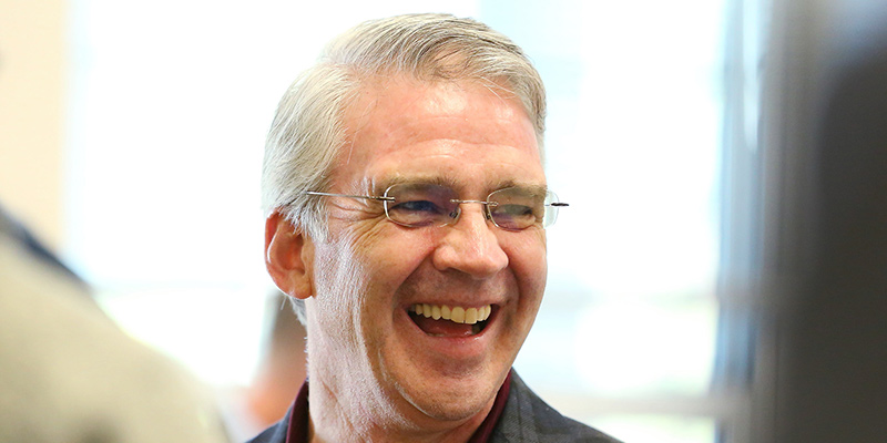 Seamus Carey laughing and smiling widely at an event.
