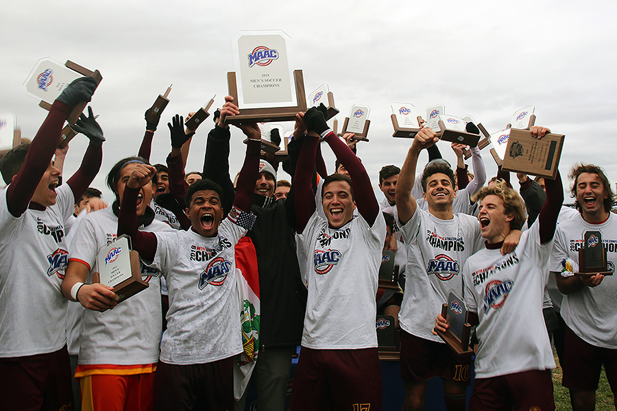 The men's soccer team holds up their MAAC trophies.