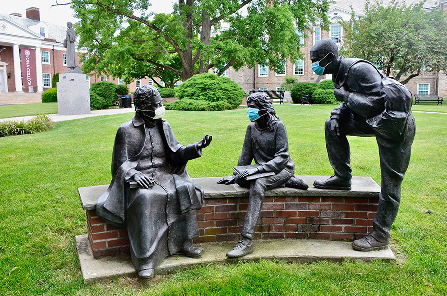 Statues on Iona's campus wearing masks.