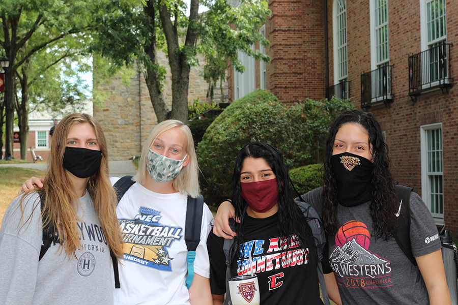 Four students in face masks pose for the camera.