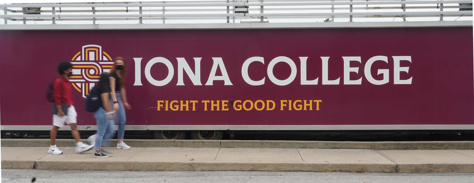 Students walk in front of the fight the good fight banner near mazzella field.