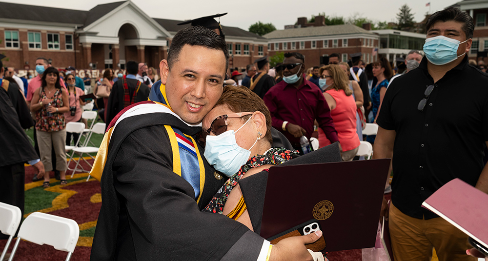 Billy Falla hugs his family member at the commencement ceremony.