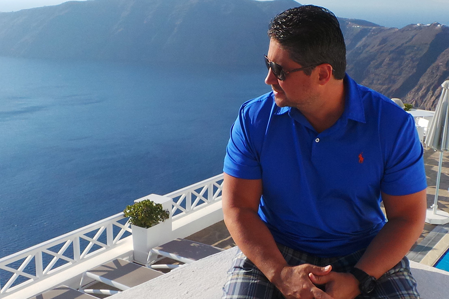 Mike Damergis ’89, ’06MS, media & strategic communications professor, in Santorini overlooking the Aegean Sea.