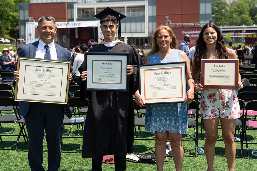 The Estrella family hold up their degrees at the 2022 Commencement Ceremony.
