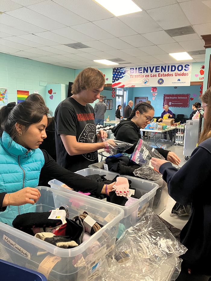 Iona students prepare bags of clothing for migrants.